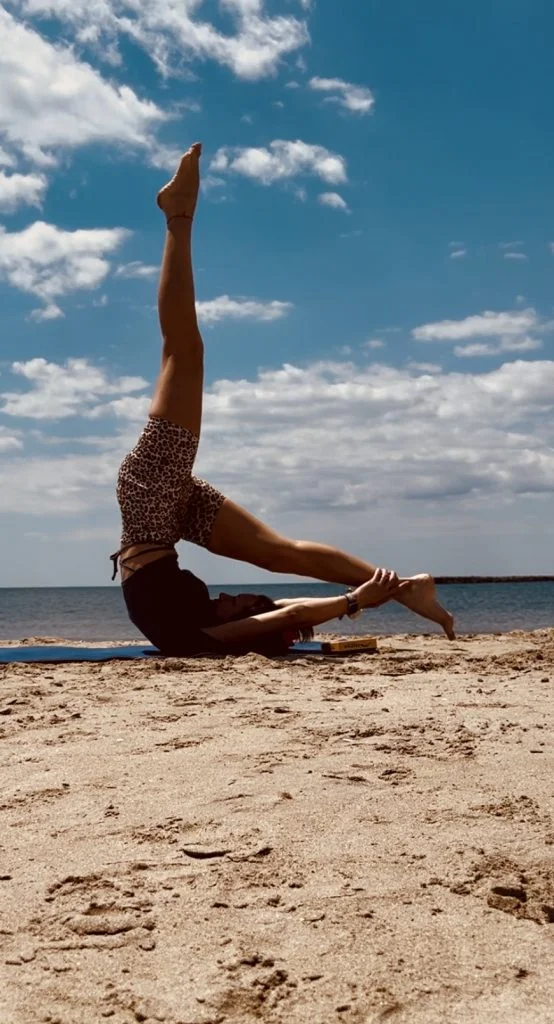 Pratique d’un exercice de Pilates en extérieur, jambe levée vers le ciel